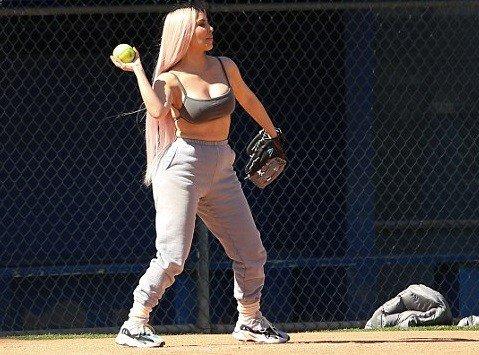 Kim K flaunts her cleavage and flat tummy in sports bra as she joins her famous family for softball game