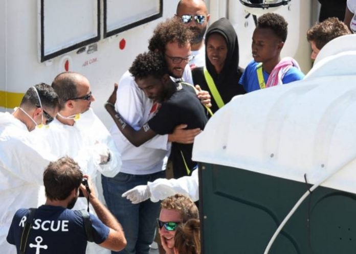 Migrants say goodbye to crew members as they disembark from the Aquarius rescue ship after it docked at Bolier Wharf in Senglea, Malta, on August 15, 2018. The Aquarius, chartered by French group SOS Mediterranee along with Doctors Without Borders (MSF), arrived in Malta on August 15 after EU countries thrashed out a deal to take in the 141 migrants onboard, defusing another diplomatic standoff. The Aquarius had rescued the migrants off the coast of Libya in two separate missions on August 11, only for Italy and Malta to refuse access to their ports. / AFP PHOTO / Matthew Mirabelli