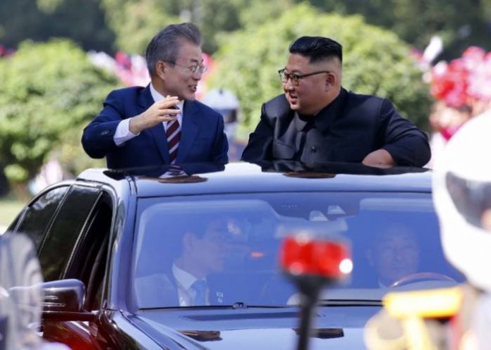 North Korean leader Kim Jong Un (R) talks with South Korean President Moon Jae-in (L) in an open-topped vehicle as they drive through Pyongyang on September 18, 2018.South Korea's president and the North's leader Kim Jong Un drove through the streets of Pyongyang together past thousands of cheering citizens on September 18, ahead of a summit where Moon Jae-in will seek to reboot stalled denuclearisation talks between North Korea and the United States. / AFP PHOTO / Pyeongyang Press Corps / - /