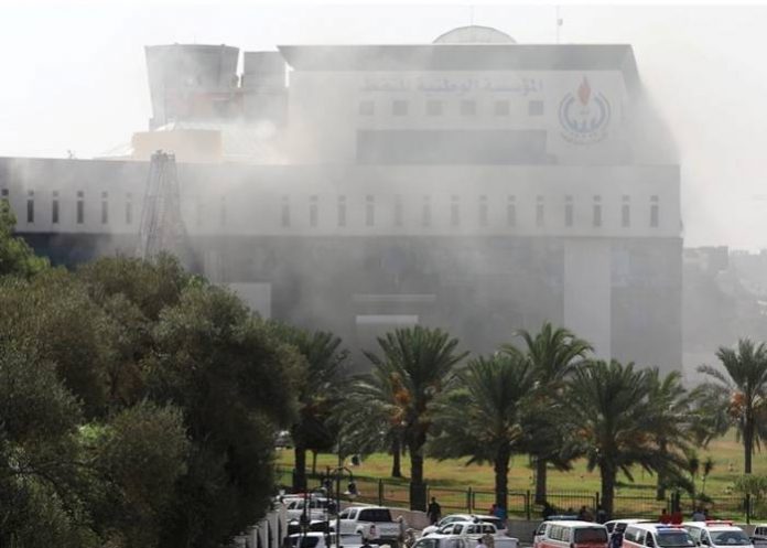 Smoke shrouded the headquarters of the Libyan National Oil Corporation (NOC) in Tripoli [Hani Amara-Reuters]